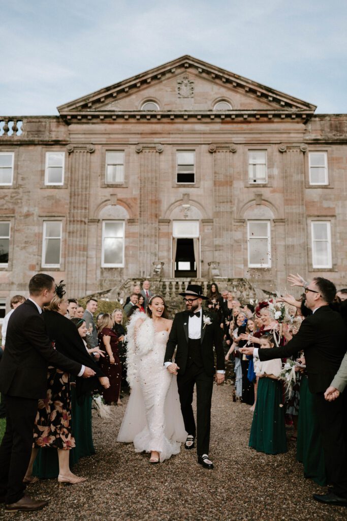 Luxury wedding photography Scotland couple confetti exit outside elegant country house venue