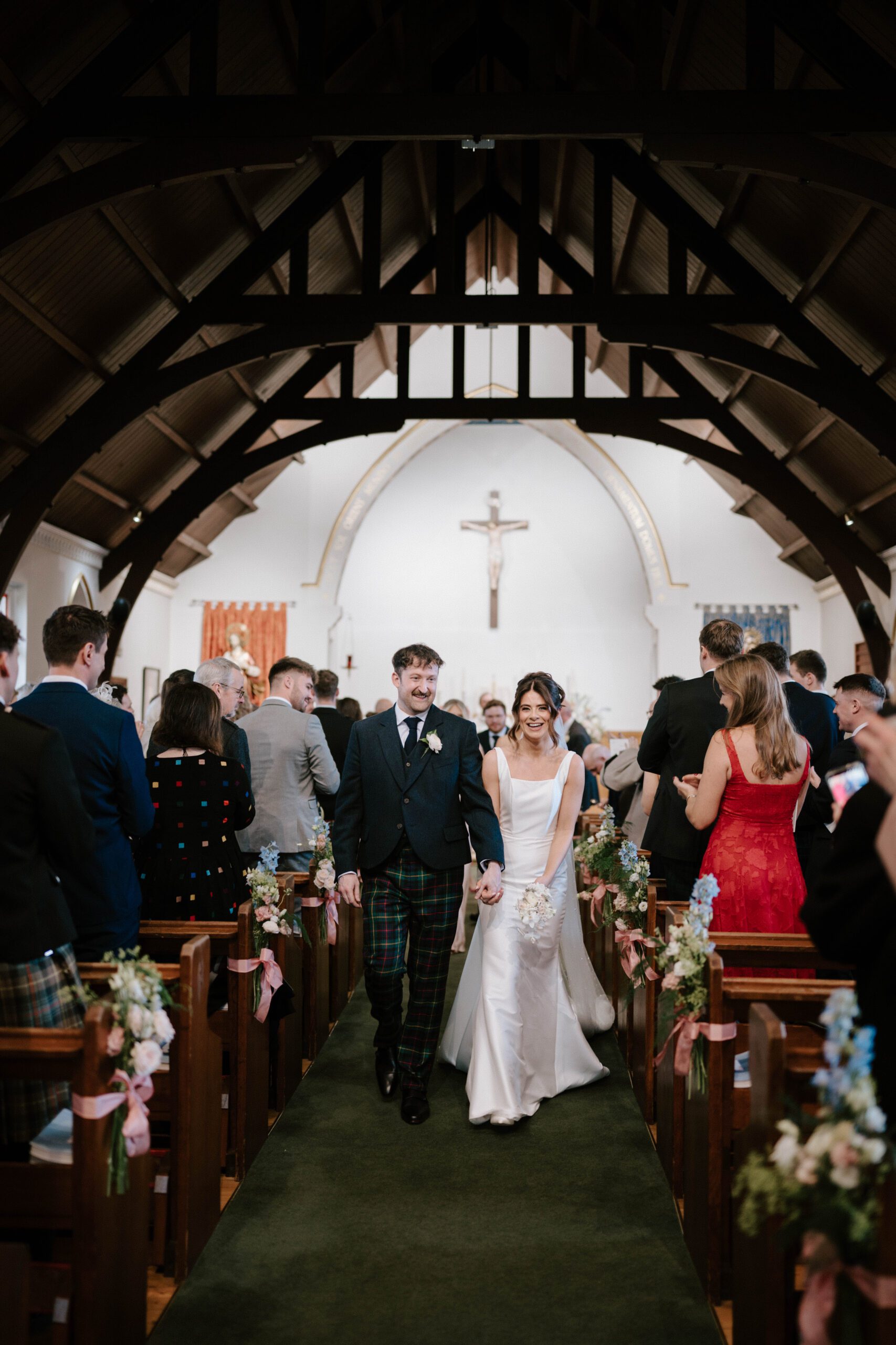 luxury wedding photographer in Scotland bride and Groom walking hand in hand after ceremony celebations