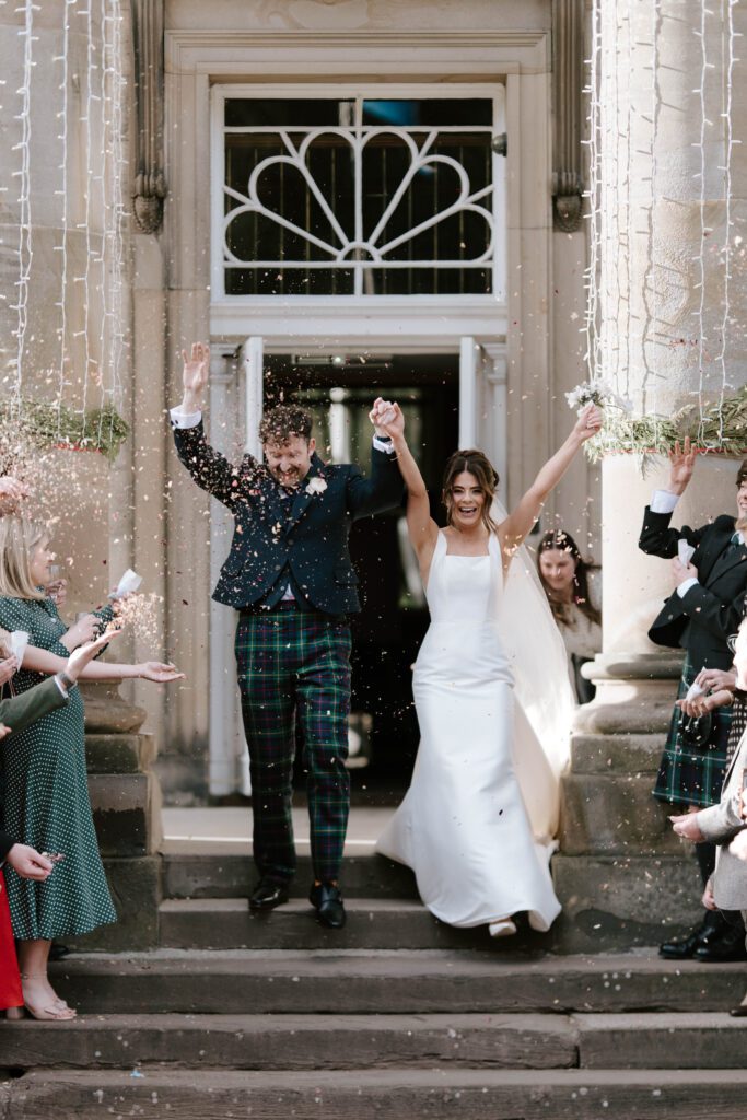 Bride and groom walking out of Balbirie house Hotel after ceremony, elegant Scotland wedding photography